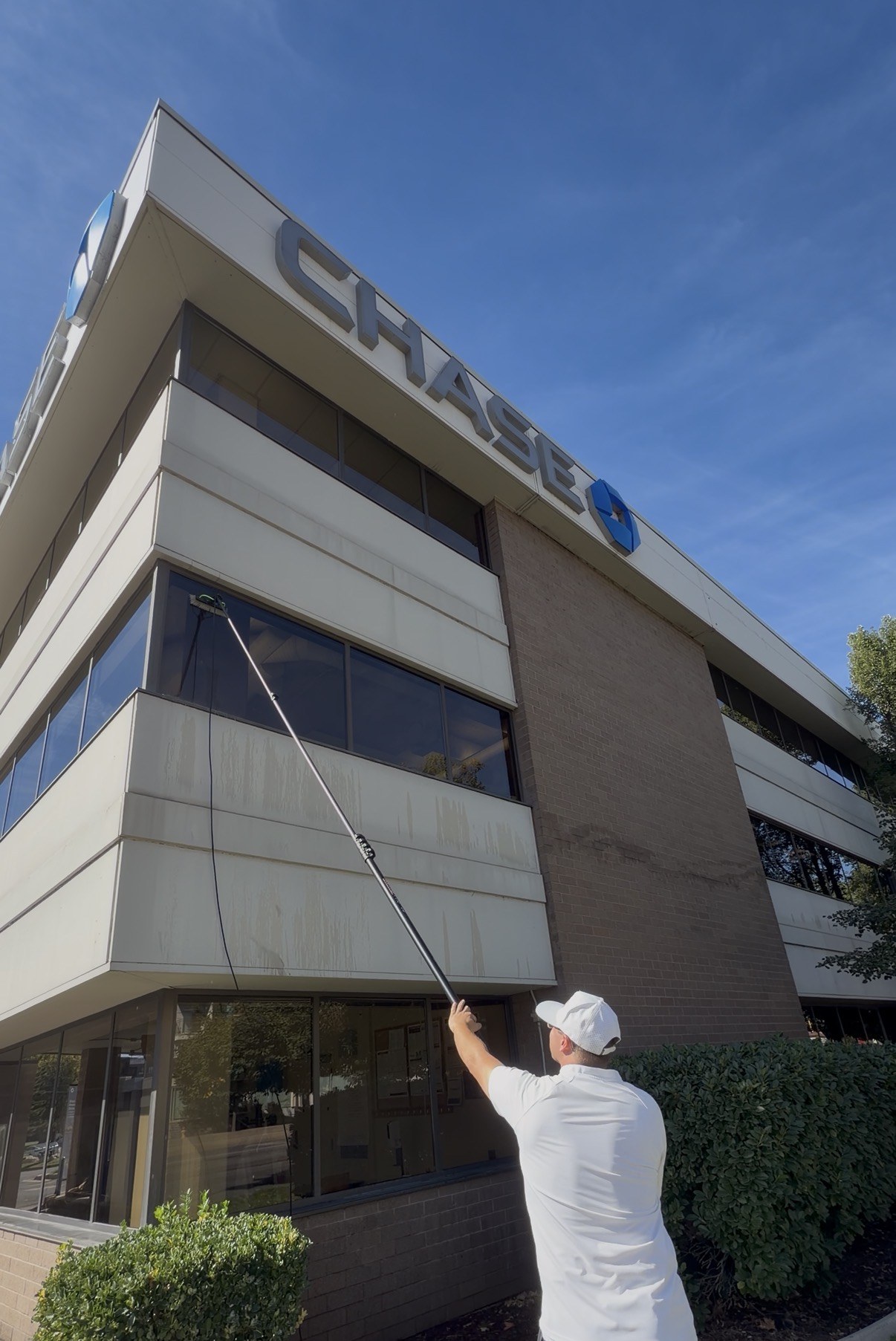 Water-fed pole cleaning on a commercial building